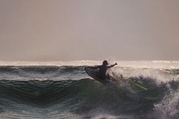 Surfer doing a snap maneuver on a wave © Adrian Iglesias