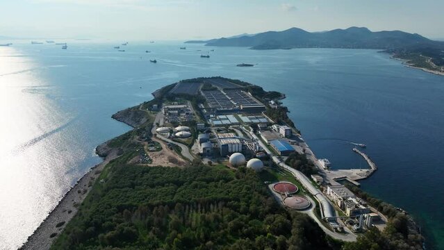 Aerial drone video of small industrial island of Psitaleia the largest sewage treatment plant in Europe, Saronic gulf, Peiraeus, Attica, Greece