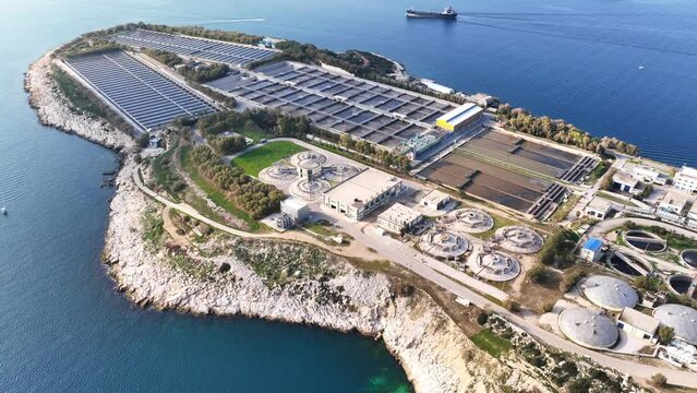 Aerial drone video of small industrial island of Psitaleia the largest sewage treatment plant in Europe, Saronic gulf, Peiraeus, Attica, Greece