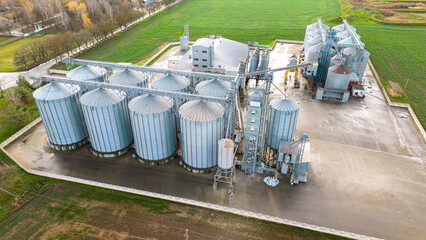 Drone flight over a large agro-industrial complex and barrels of grain. silos at the agro manufacturing plant for processing, drying, cleaning and storage of agricultural products, flour, cereals © Pokoman