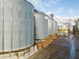 silver silos on agro manufacturing plant for processing drying cleaning and storage of agricultural products, flour, cereals and grain. Flying a drone over iron barrels of grain. quadcopter photo © Pokoman