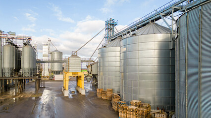 silver silos on agro manufacturing plant for processing drying cleaning and storage of agricultural products, flour, cereals and grain. Flying a drone over iron barrels of grain. quadcopter photo © Pokoman