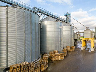 silver silos on agro manufacturing plant for processing drying cleaning and storage of agricultural...
