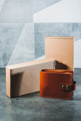 Stylish handmade brown leather wallet on a gray background. Product made of genuine leather.