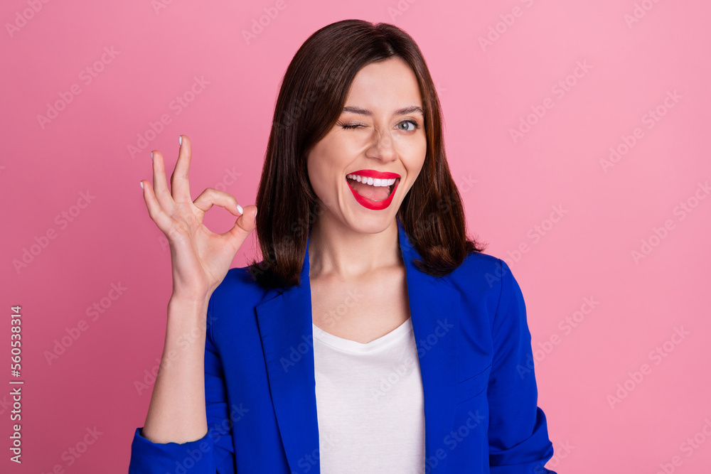 Sticker Photo of young funny blink eye flirty business woman wear blue blazer showing okey sign work done everything cool isolated on pink color background