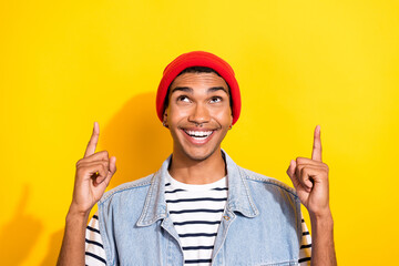 Photo of positive cool guy wear trendy clothes two arm presenting empty space proposition low prices isolated on yellow color background