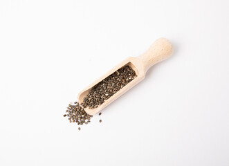 Chia seeds in wooden spoon isolated on white background. Superfood.