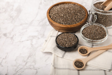 Bowl and spoon with chia seeds on a white marble table. Superfood. Proper nutrition. Diet. Healthy food. Place for text. Place to copy.