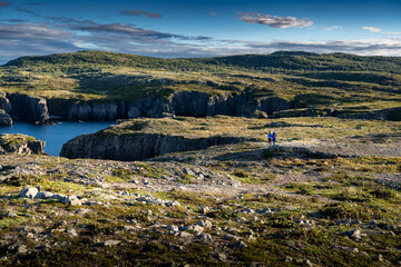Mother and daughter on a walk across mossy tundra along the Klondike trail near the famous Chimney Rock in Newfoundland Canada.