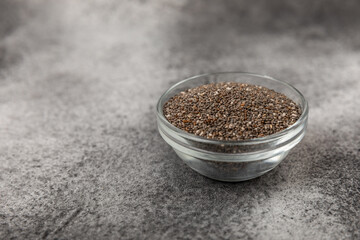 A bowl of chia seeds on a texture table. Superfood. Proper nutrition. Diet. Healthy food. Place for text. Place to copy.