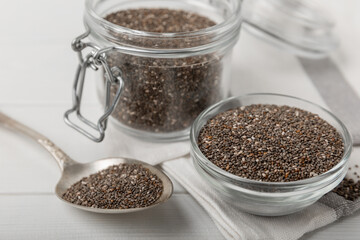 Bowl and spoon with chia seeds on a white wooden table. Superfood. Proper nutrition. Diet. Healthy food. Place for text. Place to copy.