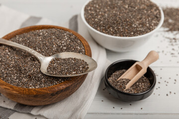 Bowl and spoon with chia seeds on a white wooden table. Superfood. Proper nutrition. Diet. Healthy food. Place for text. Place to copy.