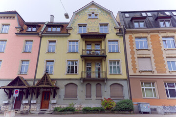 Fototapeta na wymiar Colorful facades of apartment buildings at Swiss City of Baden, Canton Aargau, on a cloudy autumn day. Photo taken November 13th, 2022, Baden, Switzerland.
