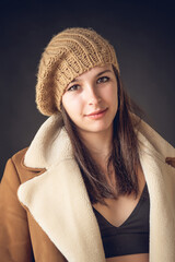 Vertical shot of a beautiful Caucasian woman posing in stylish winterwear