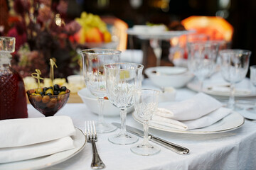 table setting for a festive dinner. empty wine glasses, tableware and snacks.
