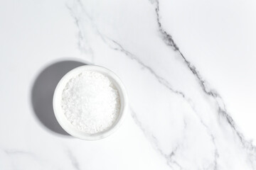 coarse sea salt on white marble background