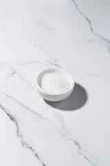 coarse sea salt on white marble background