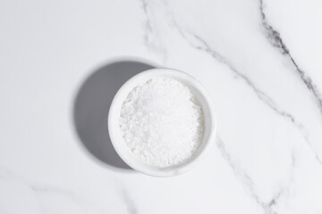 coarse sea salt on white marble background