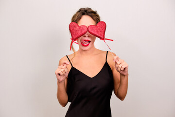 A woman with red hearts on her eyes and sticking out her tongue.