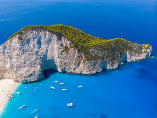 Drone shot of the famous Navagio beach and high limestone walls surrounding the shipwreck at the...