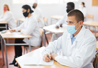 Group of medical academy students in protective masks at the lesson