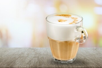 Cup of tasty sweet hot coffee on desk