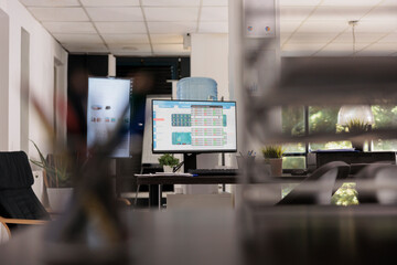 Workplace with modern electronic screen for staff meetings and conferences in a financial analysis company. Chairs in waiting room with relaxed style in the background.