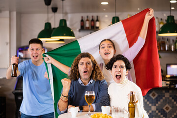 Happy fans celebrating the victory of Italian team in the bar