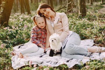 Mother with daughter in a spring forest with dog