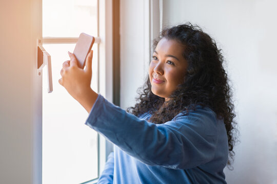 portrait beautiful chubby latin young woman taking selfies with a mobile phone indoors.
