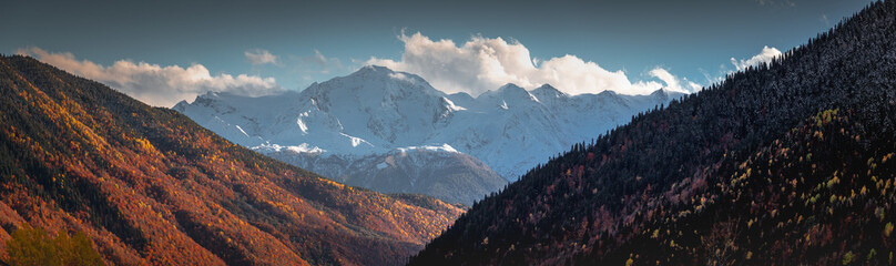 panorama autumn landscape in the mountains, view of the snowy peaks