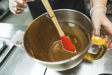 Cooking process of brownies or cupcakes. Liquid batter. Melted chocolate in a bowl with spatula....