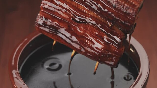 鰻の蒲焼きを秘伝のタレに漬ける