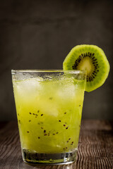 Brazilian Kiwi Caipirinha. Cachaça drink with kiwi, on wooden background.