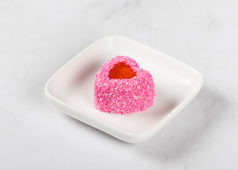Strawberry cream mousse dessert with jelly filling, in the shape of a heart, sprinkled with pink coconut chips. On a plate. White background. Valentine's day - obrazy, fototapety, plakaty