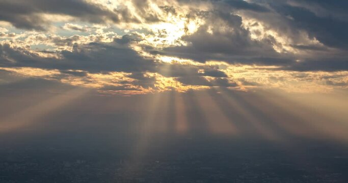 dramatic timelapse as the sun's rays seep through the clouds and illuminate the morning city below