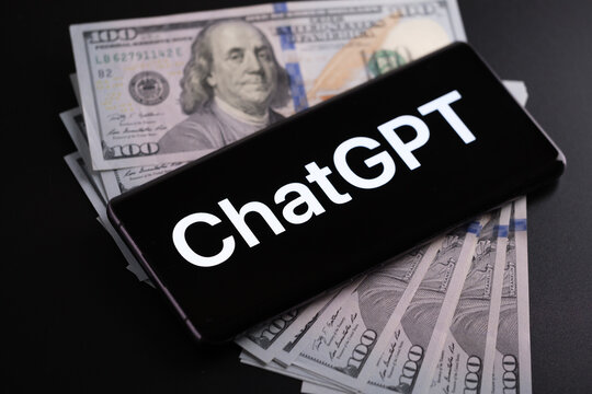 ChatGPT logo seen on smartphone placed on US dollars. Concept for making money with Chat GPT. Stafford, United Kingdom, January 11, 2023