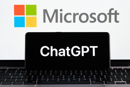 ChatGPT logol seen on the smartphone and MICROSOFT logo seen on the laptop display and dollar bills. Concept for OPENAI Chat GPT company acquisition. Stafford, United Kingdom, January 11, 2023