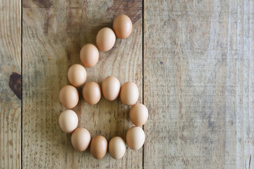 Number six written with chicken eggs, arranged on a rustic pine wood base, ideal to be used in Easter numerals.