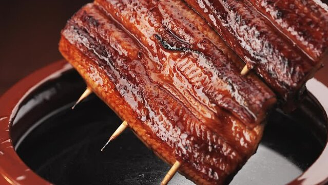 鰻の蒲焼きを秘伝のタレに漬ける