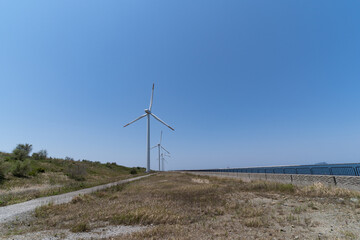 Wind power generators are on a seaside in Japan.