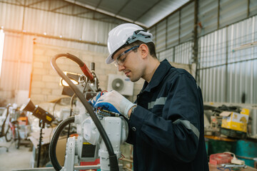 Industrial engineer wearing a white helmet working in industrial factory.	