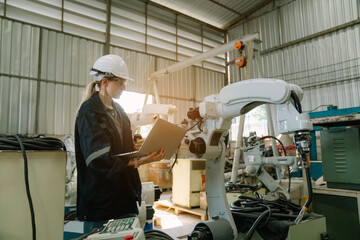 Team of engineers and technician using laptop checking and repair pressing metal machine at factory, Machine maintenance technician operation concept.	