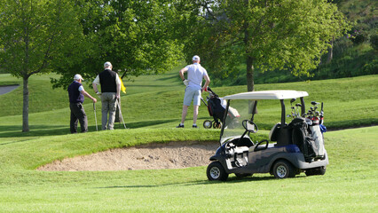 Gentlemen Golfers playing a round of golf on a sunny day at a course on a resort in UK