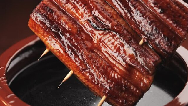 鰻の蒲焼きを秘伝のタレに漬ける