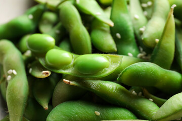 Green edamame beans in pods with sesame seeds in bowl, closeup