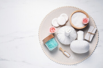 Composition of herbal bags and spa products on white marble table, top view. Space for text