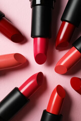 Obraz premium Many bright lipsticks on pink background, flat lay