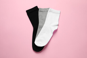 Different socks on pink background, flat lay