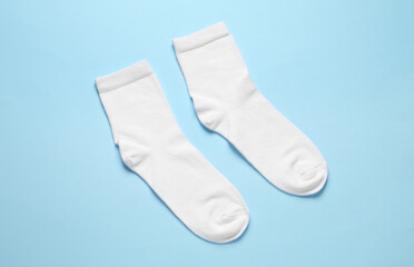 Pair of white socks on light blue background, flat lay